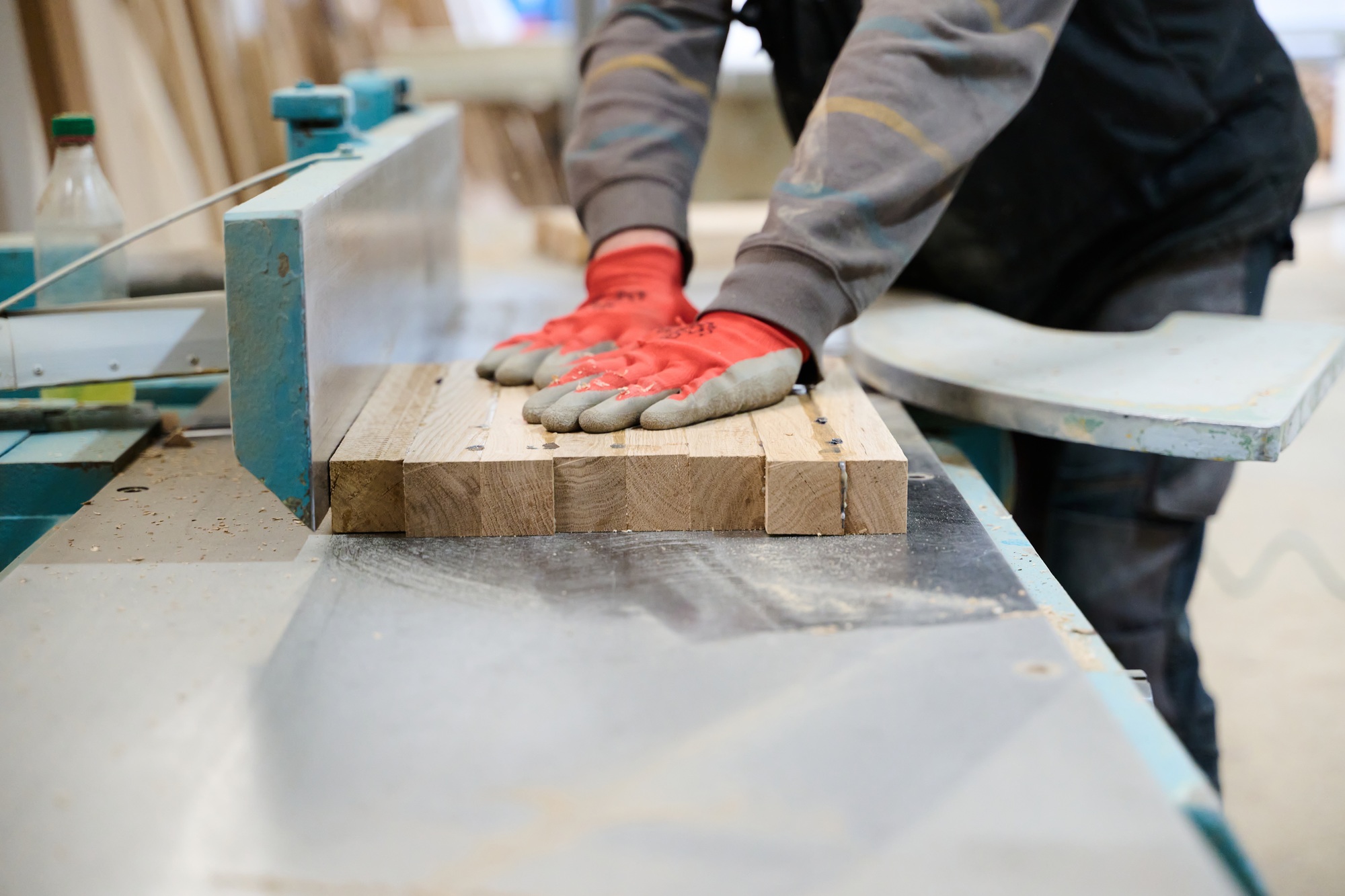 Close Up of Worker Carefully Cutting and Planing Wooden Pieces for Furniture in Wood Industry